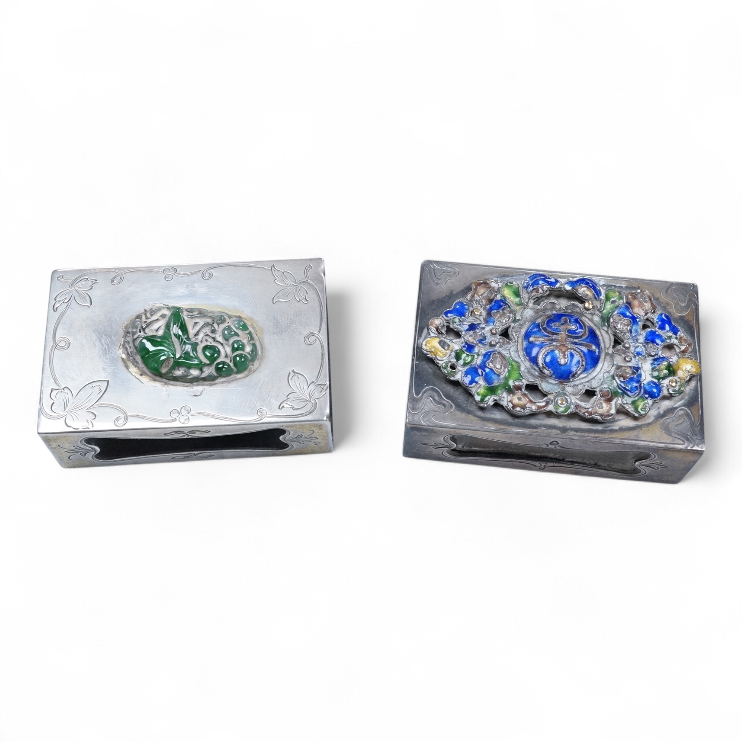 Two North American Edward I. Farmer of New York engraved sterling matchbox slides, one mounted with a jadeite carving, the other with polychrome enamelled surmount, both approximately 60mm.